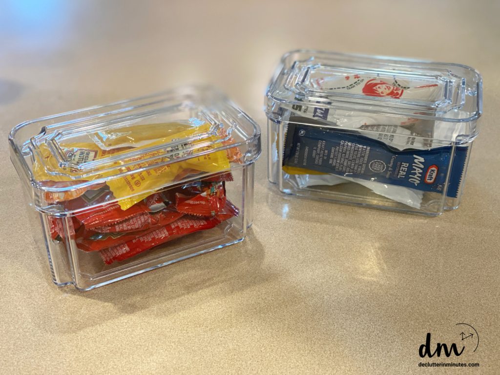 plastic containers filled with condiment packets sitting on a kitchen counter