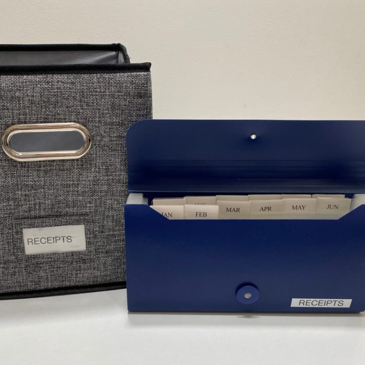 a blue accordion file next to a grew canvas bin both labeled receipts