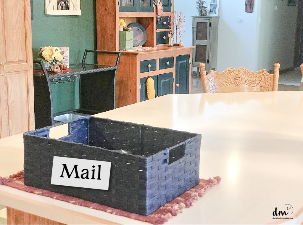 a blue basket labeled mail sitting on a counter in a kitchen