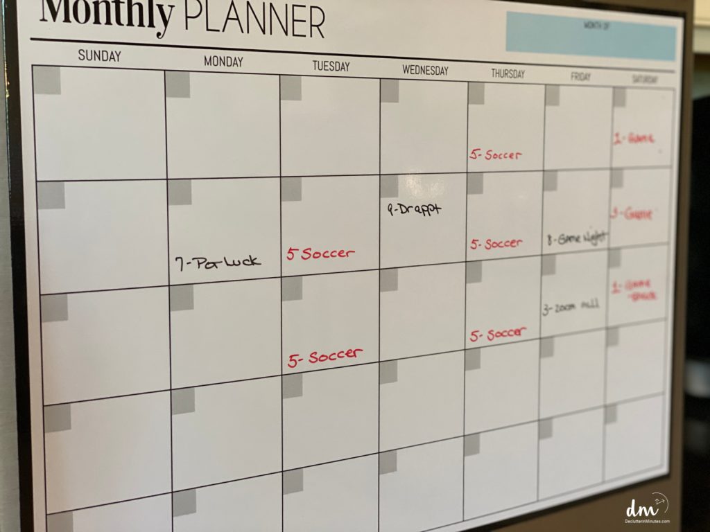 a calendar in a command center in a home with red and black writing on the days