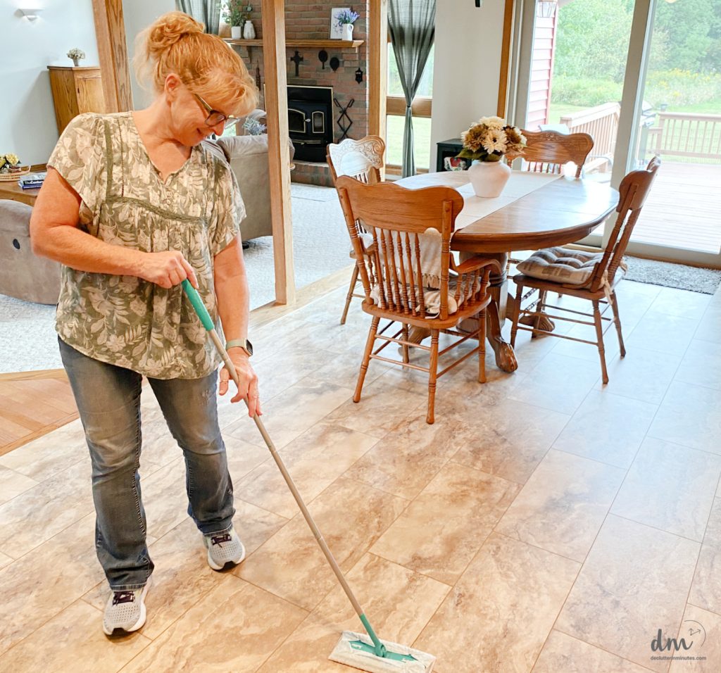 a woman sweeping a kitchen floor