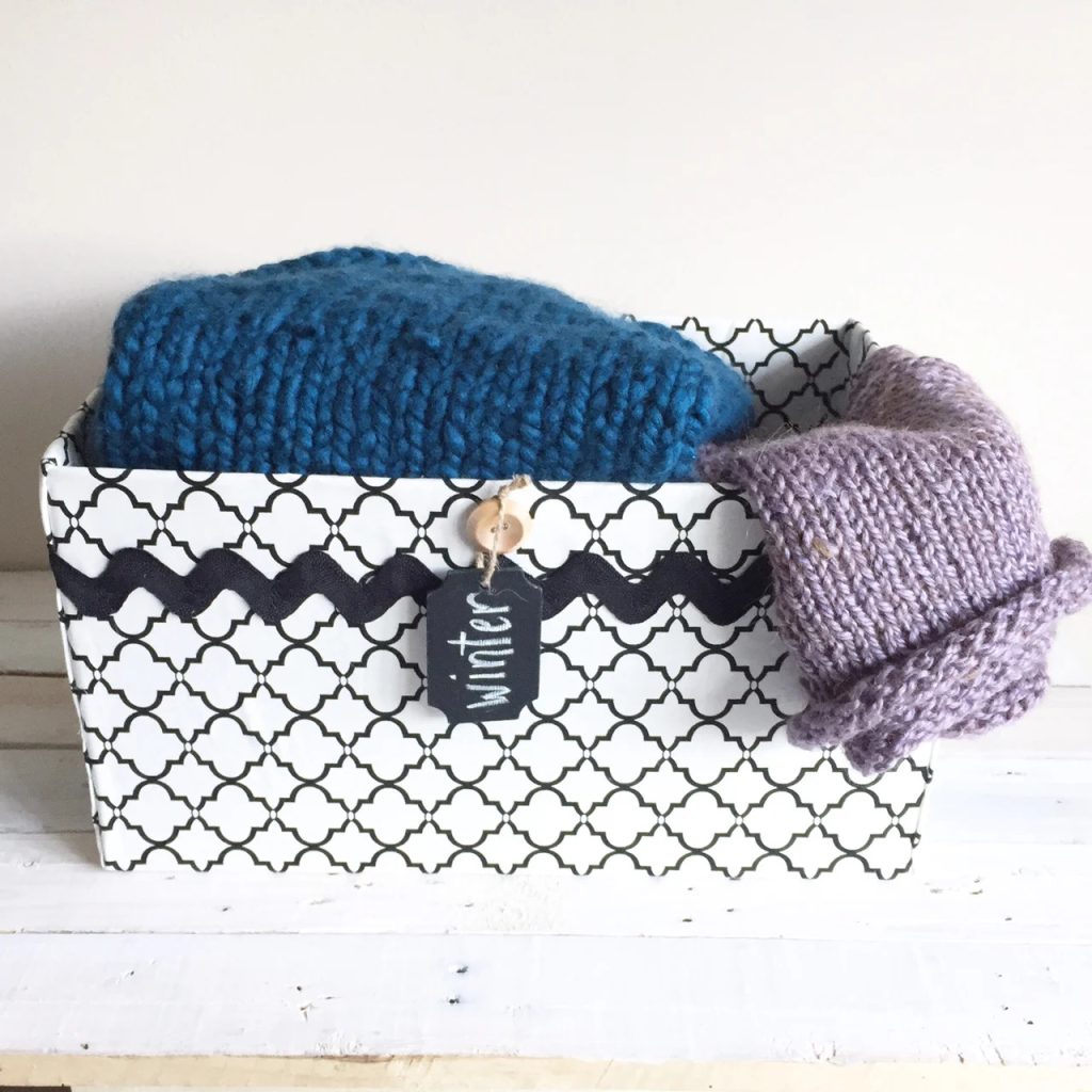 fabric-covered storage box with sweaters inside