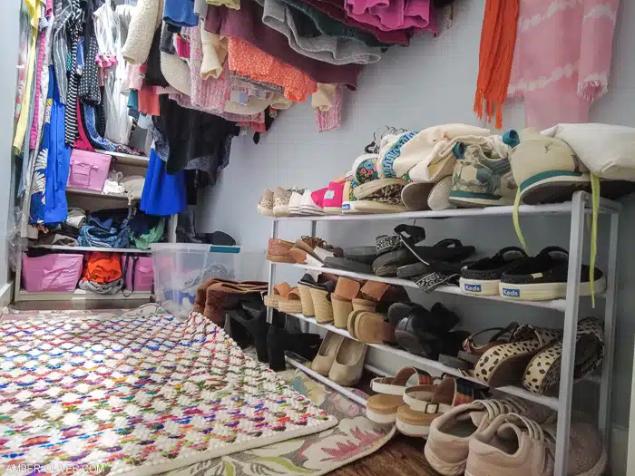 Clothes on hangers and shoes on racks in a closet