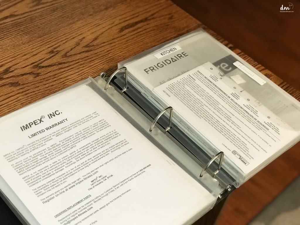 a binder with warranties inside on a desk