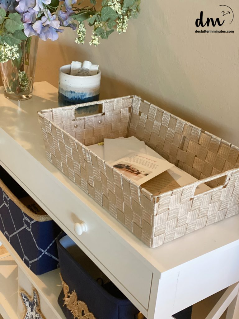 a tan basket filled with daily mail on a white table