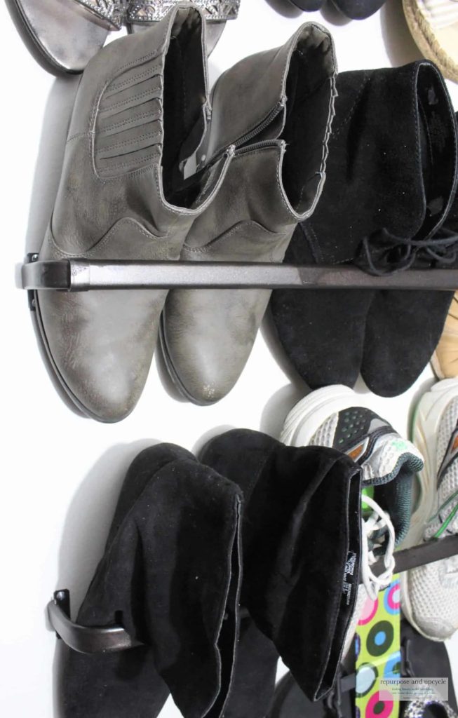A towel bar holding shoes in a closet