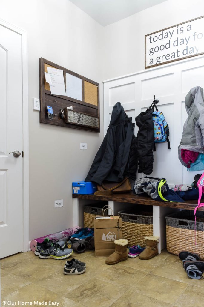 cork board, coats, shoes and storage boxes in the mudroom