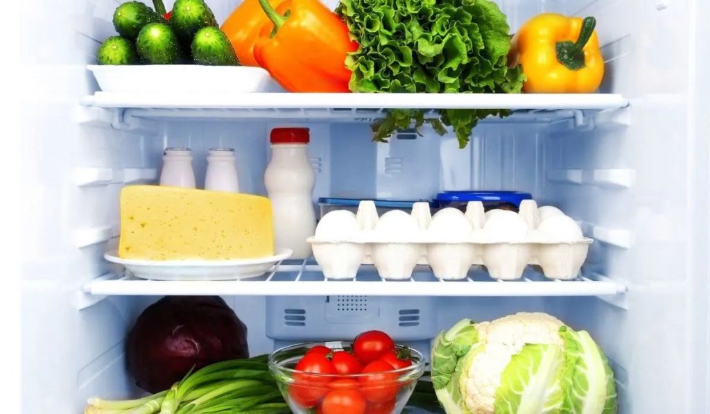 milk, eggs and veggies inside the refrigerator