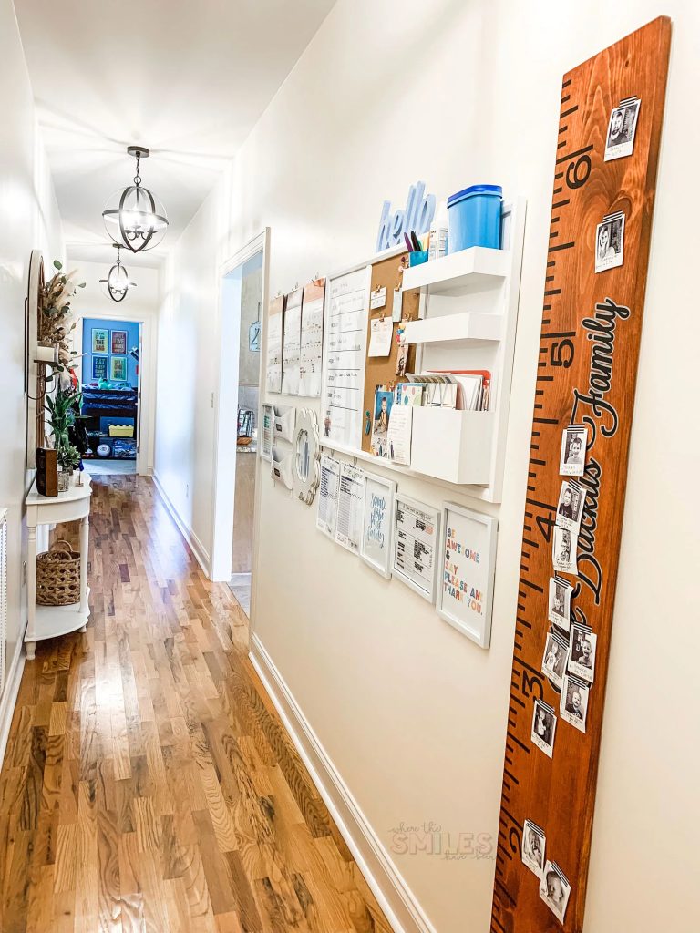 Family command center in the hallway, with a corkboard, calendar, frames, and paper and pen storage solutions