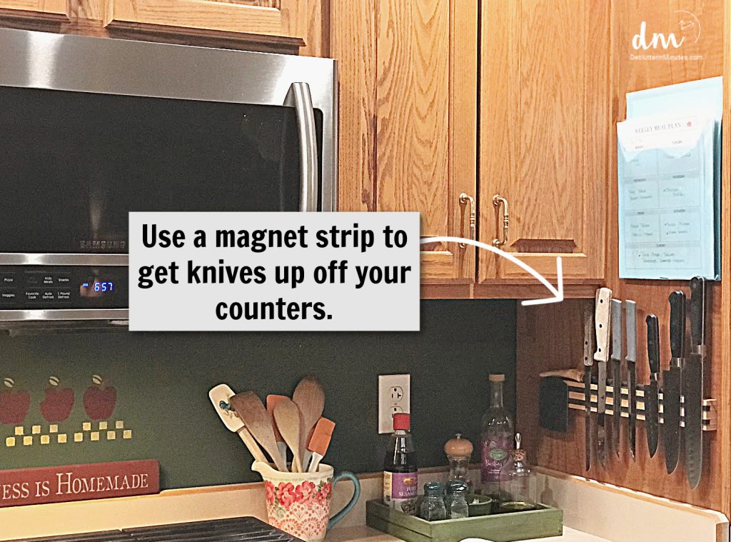 kitchen counter with a magnetic strip holding various knives next to a microwave