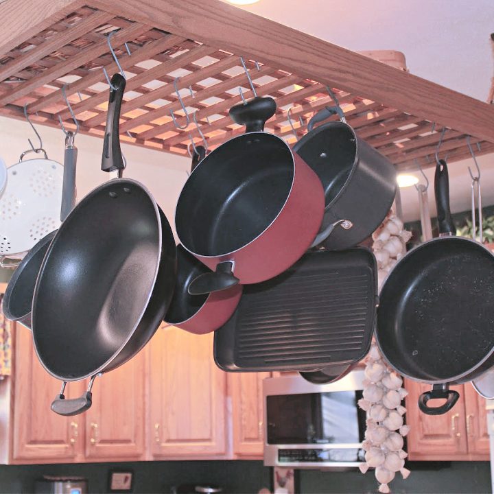 a-rack-hanging-from-a-kitchen-ceiling-holding-pots