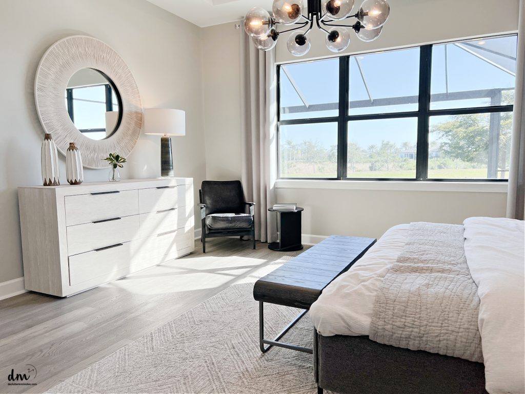a neat dresser in a bedroom with a large open window looking outside