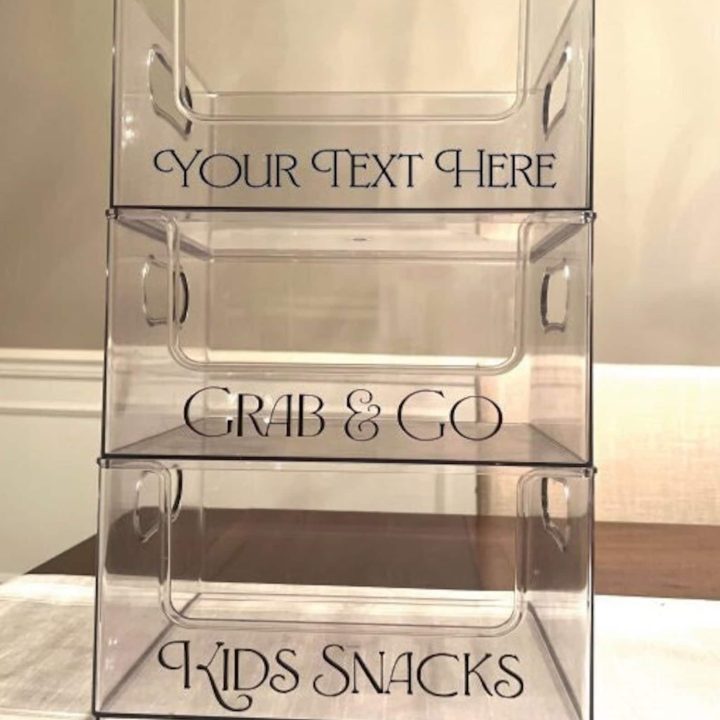 Clear acrylic storage bins labeled for organizing snacks and easy grab-and-go items