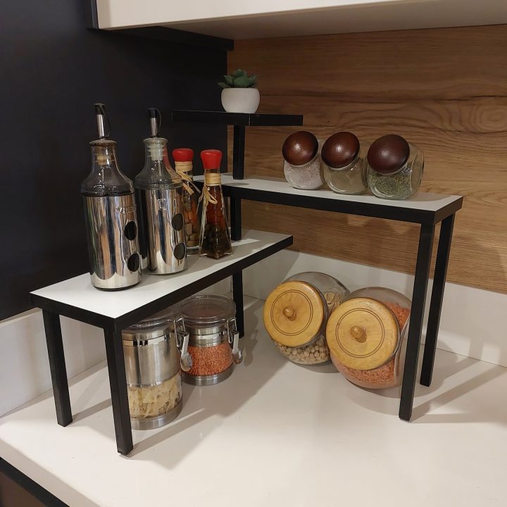 A kitchen corner shelf with jars of spices, oils and other pantry essentials