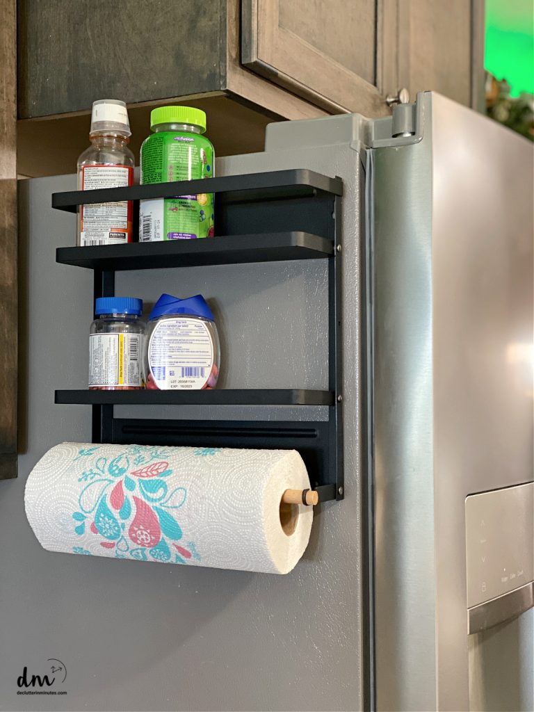 magnetic shelves on a fridge holding medicine in a small kitchen