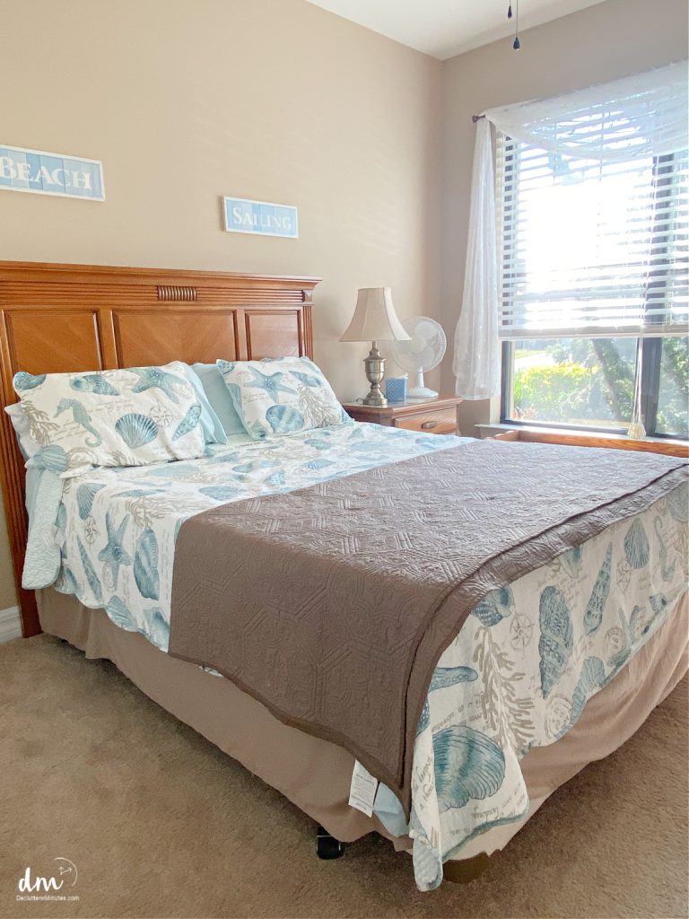 a summer bed with a brown blanket in a room next to a bright window 