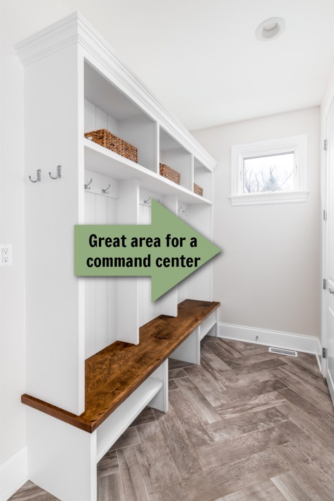 benches and hooks in a white mudroom of a home with a green arrow pointing to an open wall
