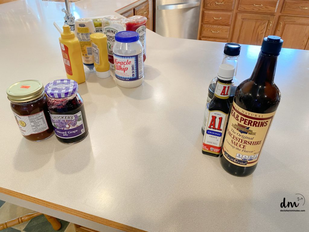 condiments being sorted on a kitchen counter from a refrigerator