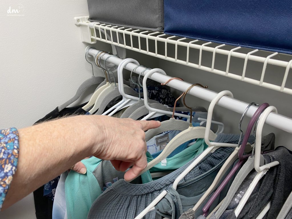 hands pointing to a backwards hanger in a closet 