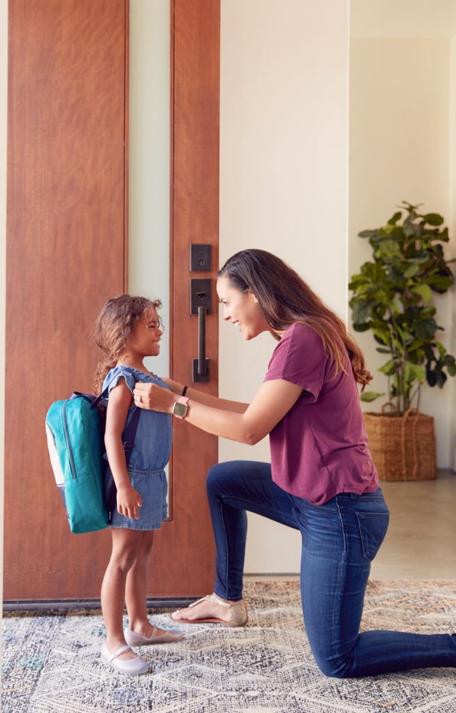 a mom saying goodbye to her daughter for school