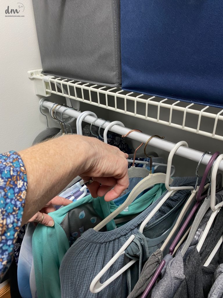 a finger pointing to a backward hanger in a closet