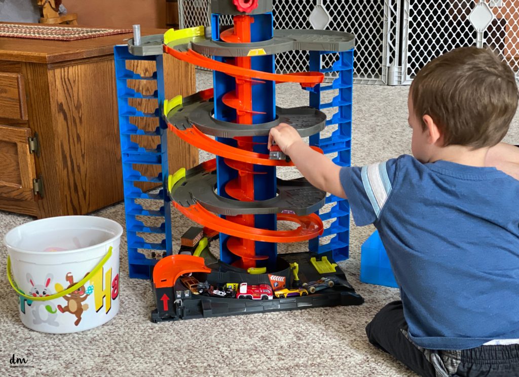 a little boy playing with a car ramp toy
