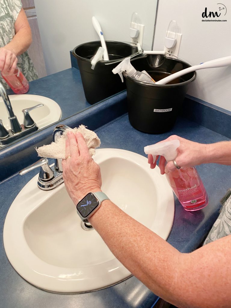 hands cleaning a sink in a bathroom