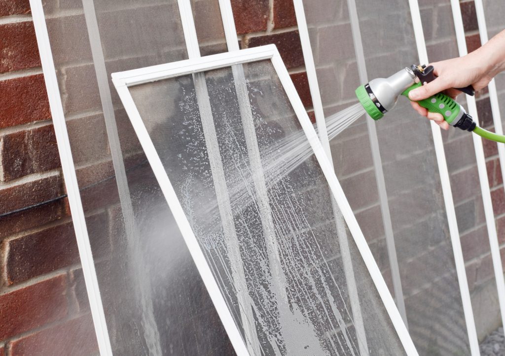 a hose rinsing window screens