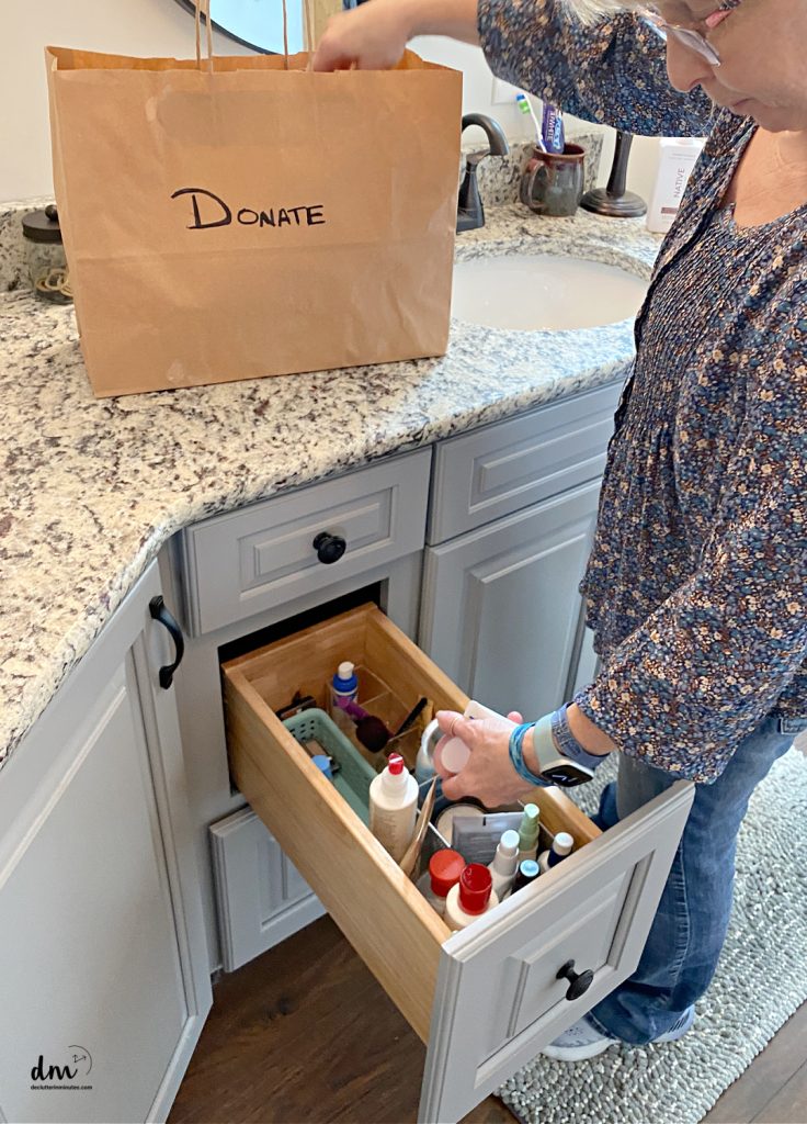 a woman putting old lotions into a donation bag