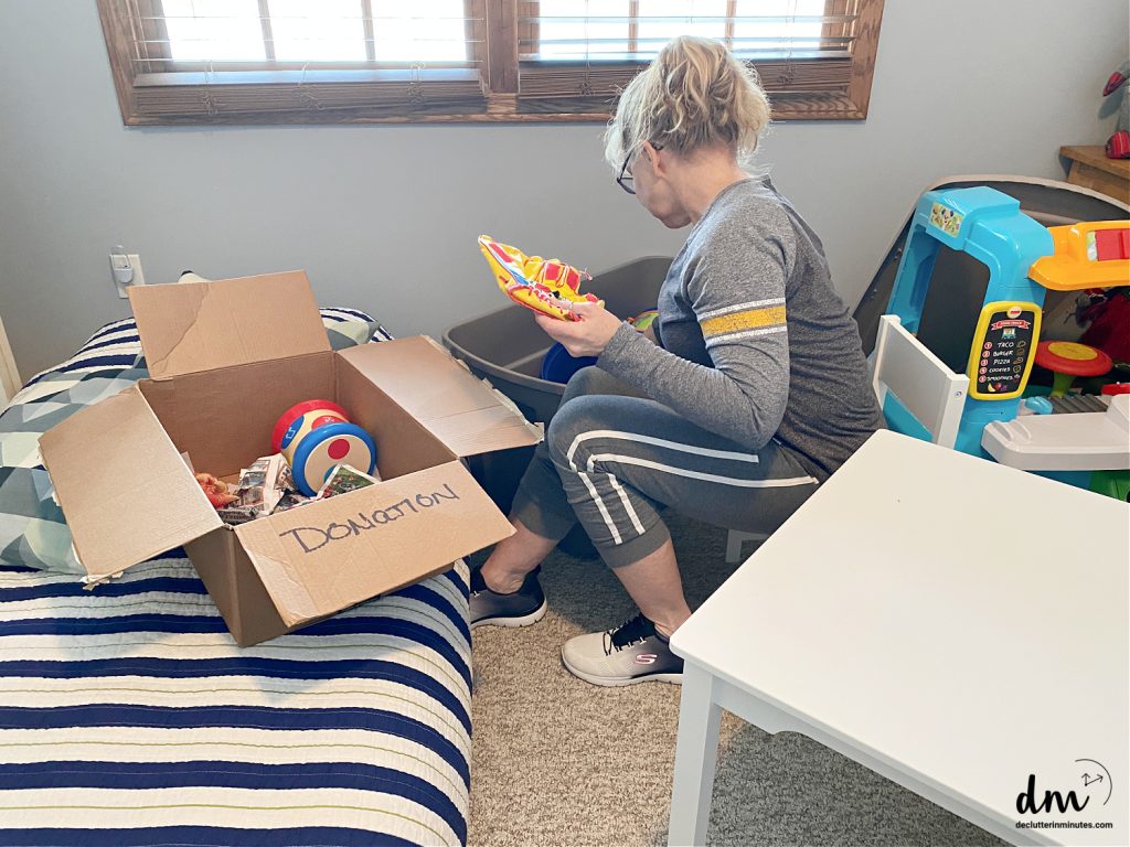 a woman sorting toys in a kid's bedroom