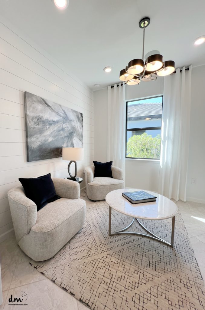an organized sitting area with chairs and a table 