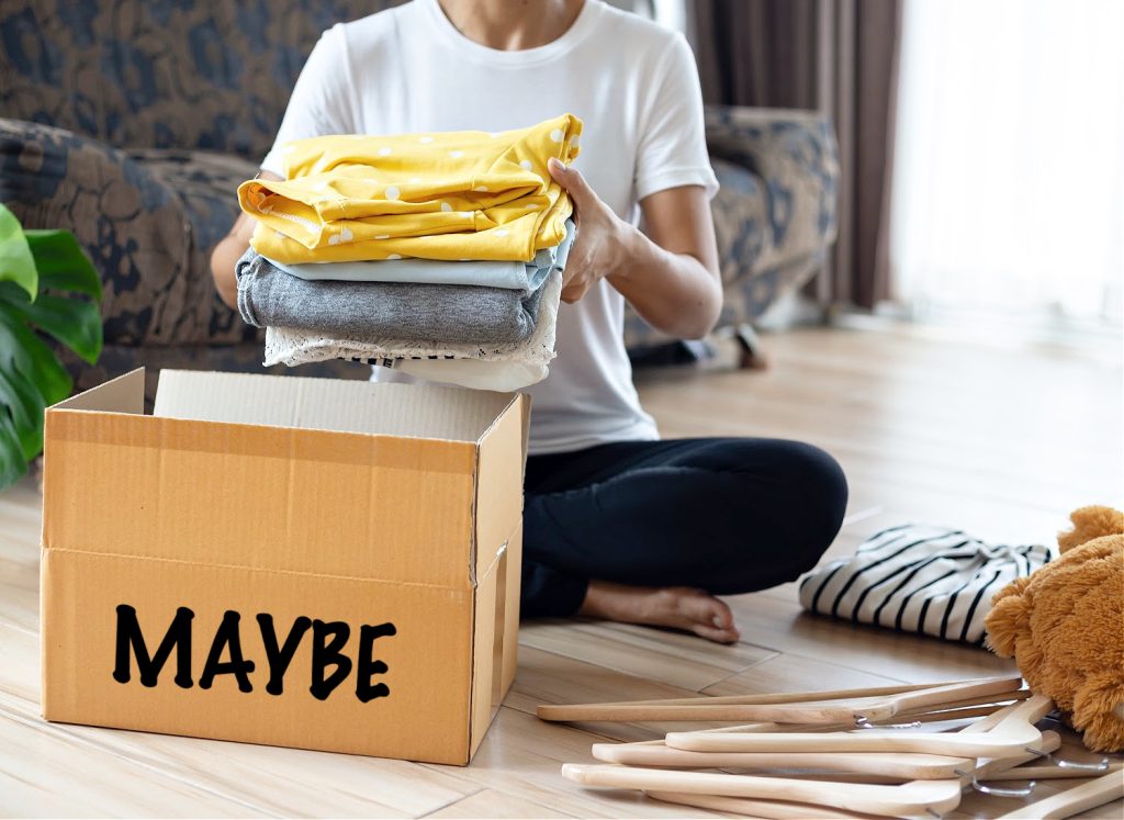 Woman holding Clothes with Maybe Box In her room