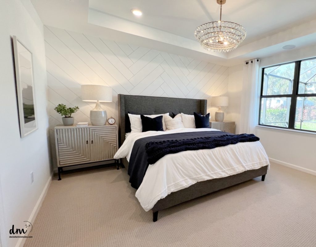 a neat and organized bedroom with a window and nightstand