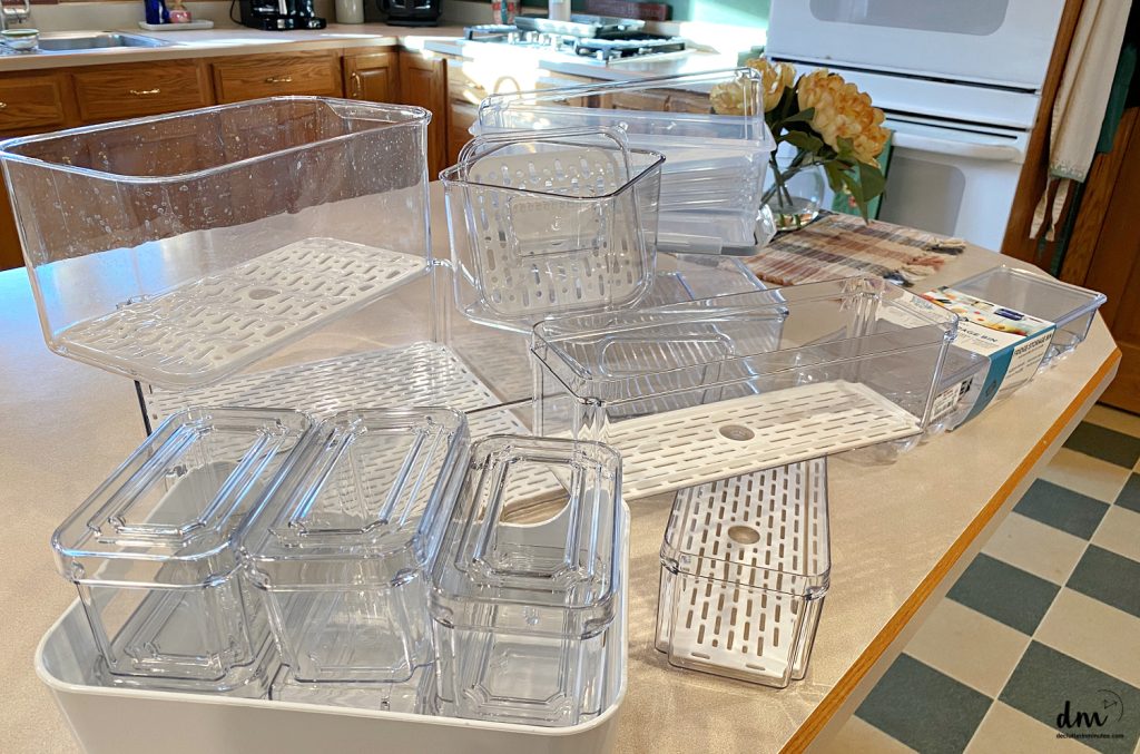 a pile of fridge organizers on a kitchen counter