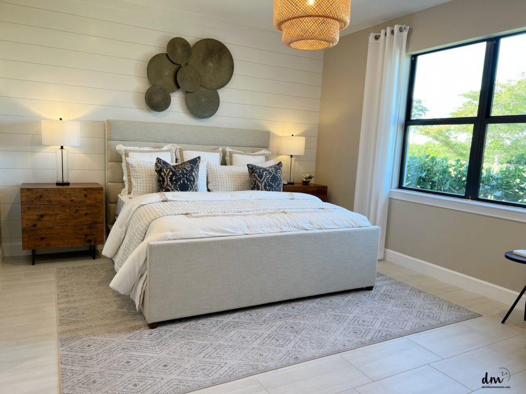 a tan bed next to a brown nightstand near to a window