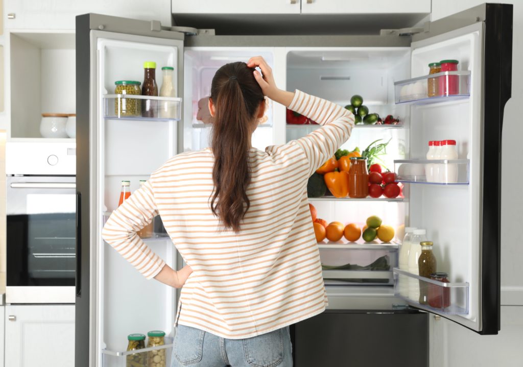 a woman looking into a fridge
