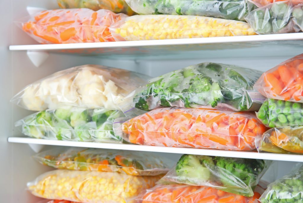 flat bags of produce stacked up in a freezer
