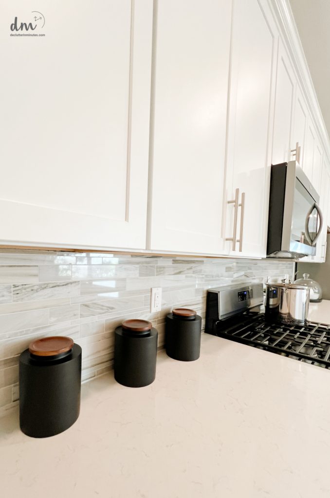 canisters on a clean kitchen counter next to a stove
