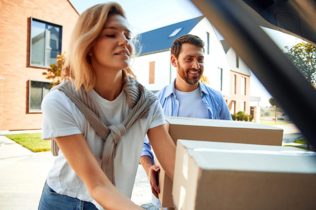 a couple loading the back of a car with boxes