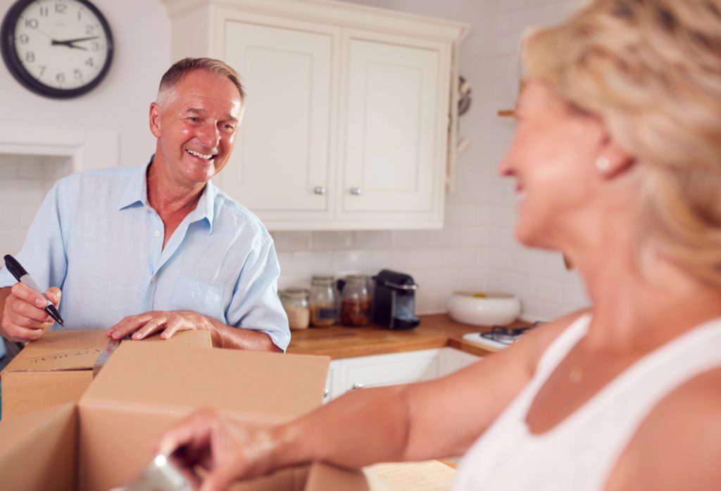 labeling a box in a kitchen packing up and downsizing