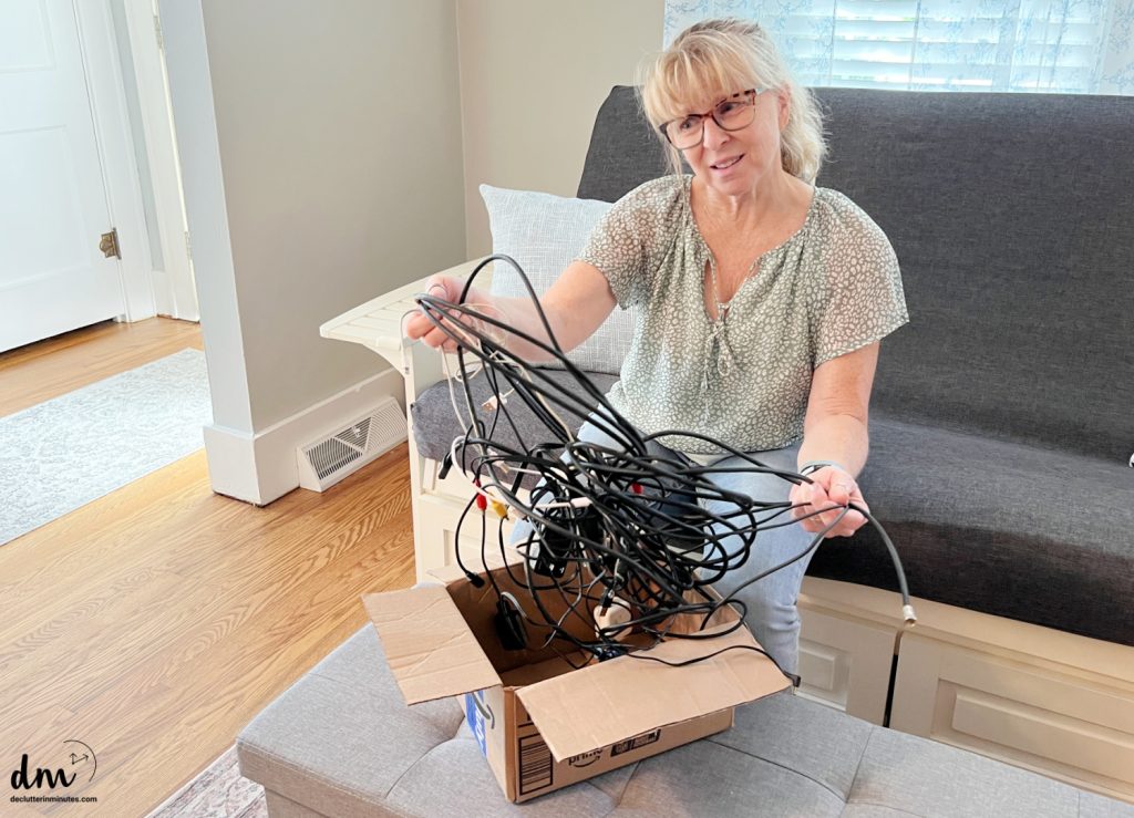 a woman struggling with a box of tangled cords
