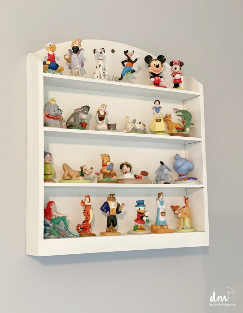 collection of Disney figurines on a white shelf in a bedroom