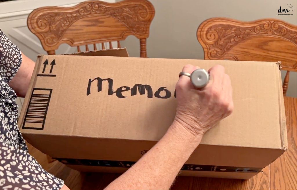 hand writing memories on the side of a box with a chunky marker