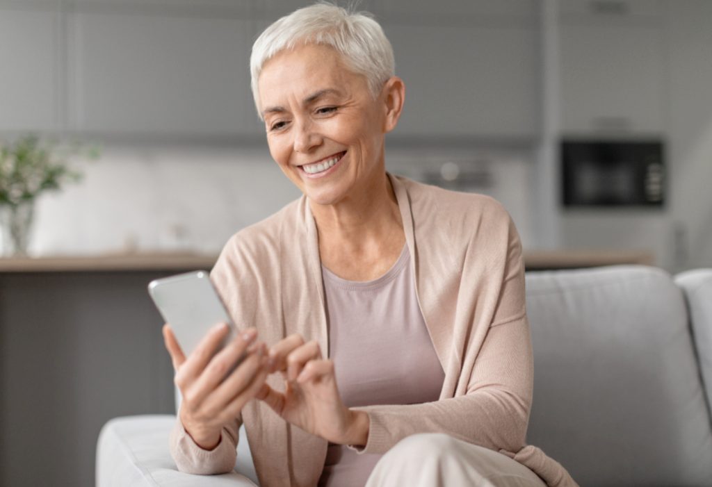 laughing senior woman texting on phone