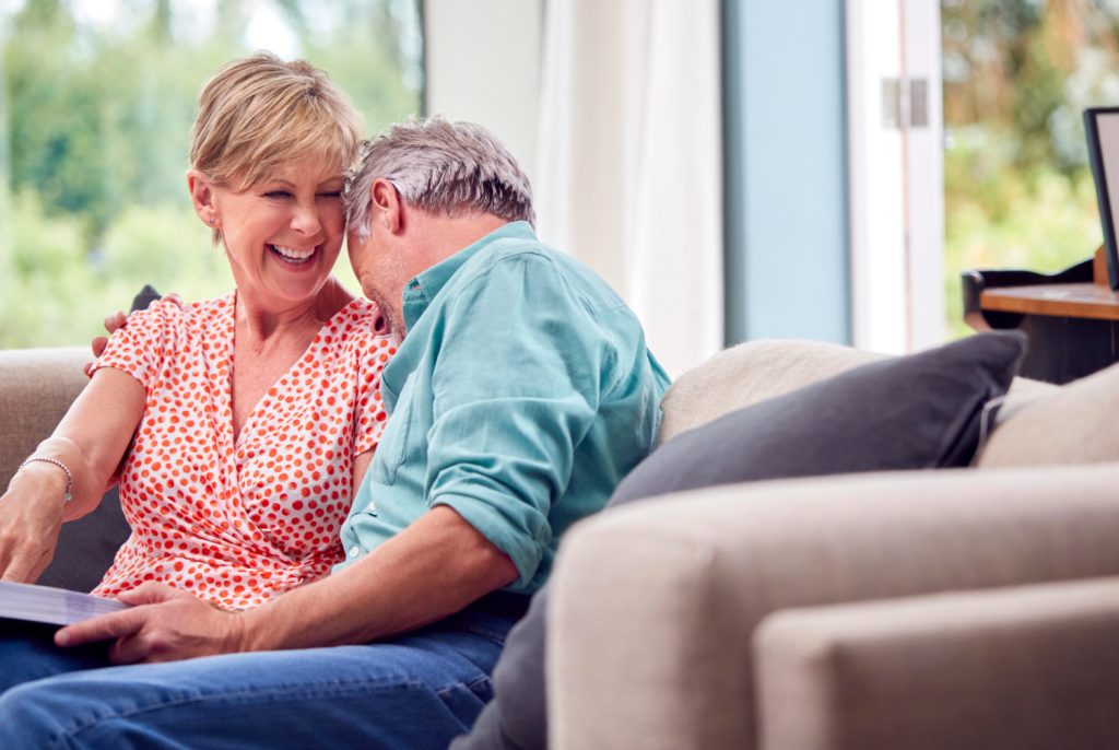 a laughing couple looking at a photo album