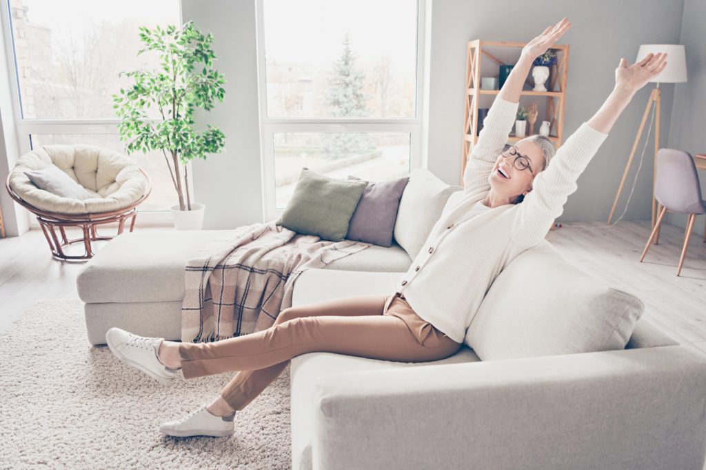 a midlife woman stretching in a lovely and cozy home