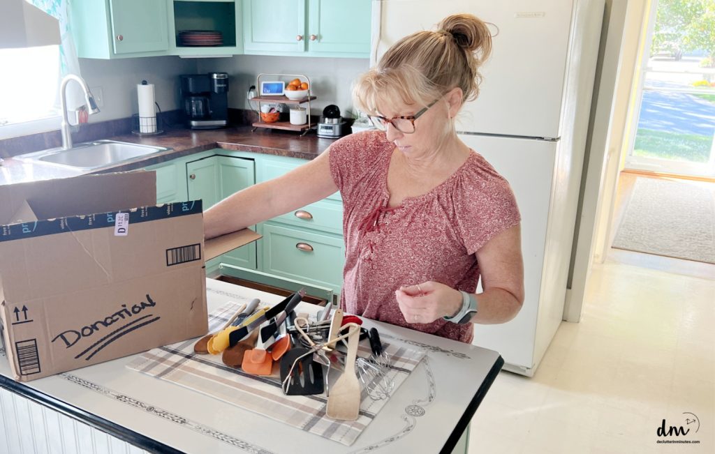 a woman in red sorting out cooking utensils in a kitchen