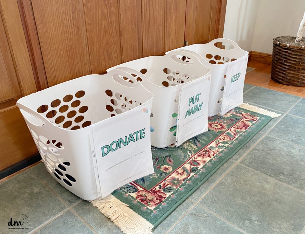 white baskets that are labeled for sorting, donate, keep toss