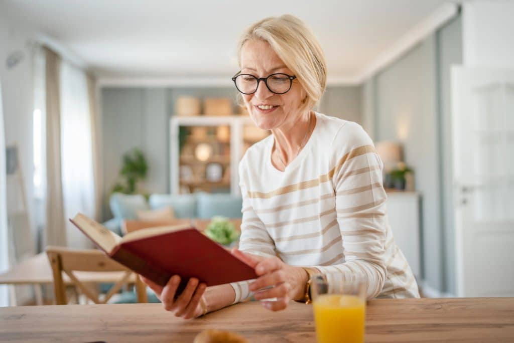 PHOTO OF A WOMAN READING HAPPY IN A ROOM