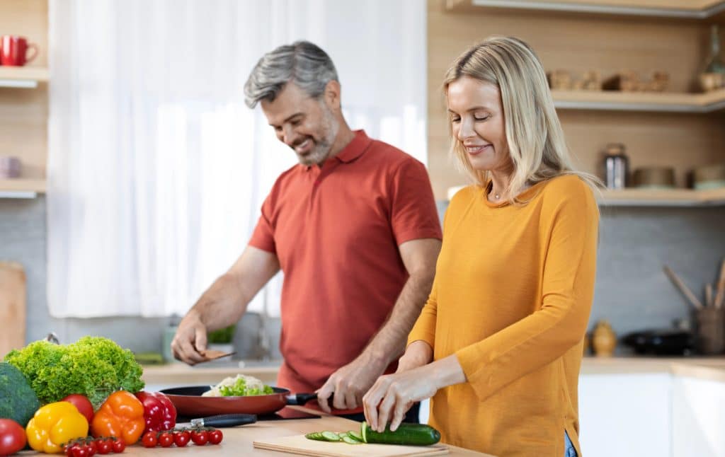 midlife couple cooking dinner